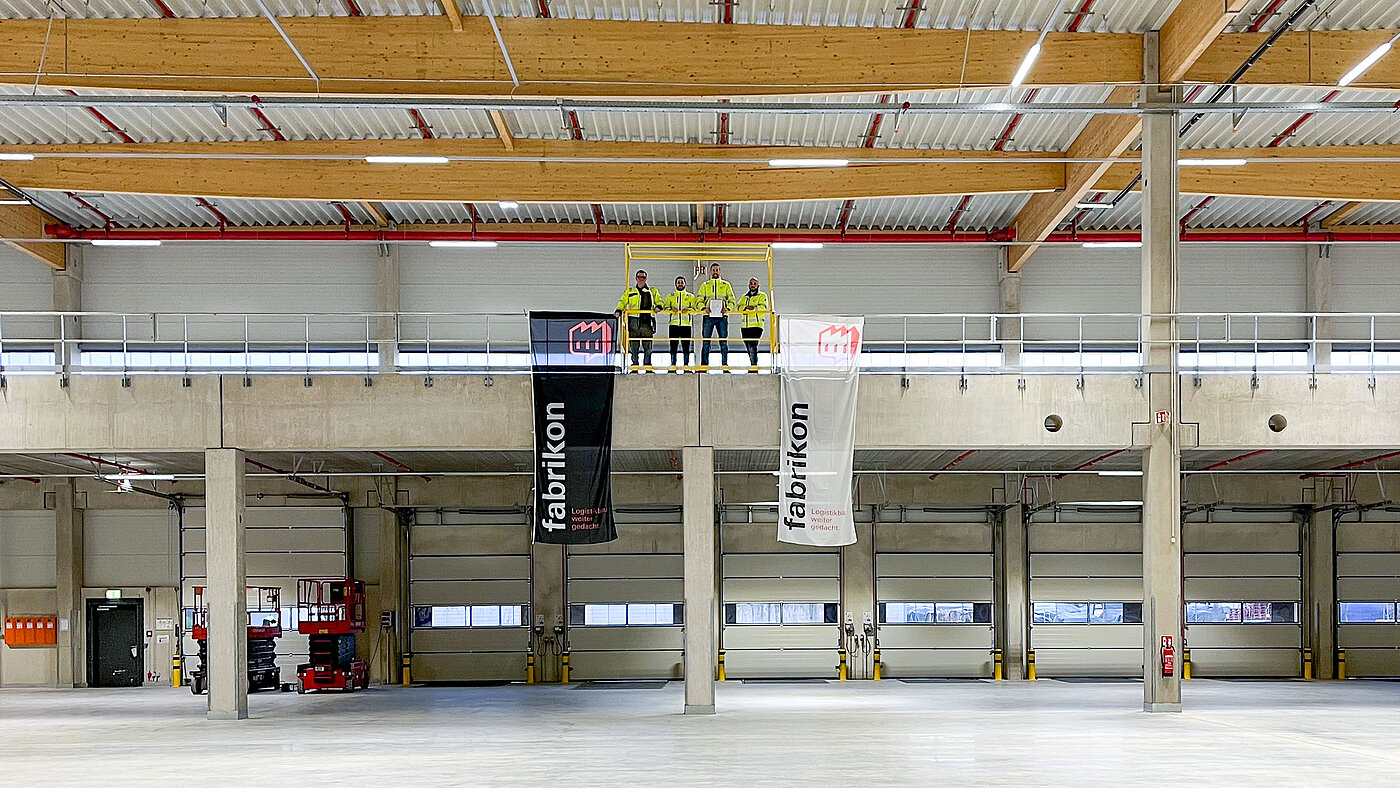 Interior view of the logistics hall in Duisburg with a view of the loading bridges and the fabrikon team on the mezzanine. 