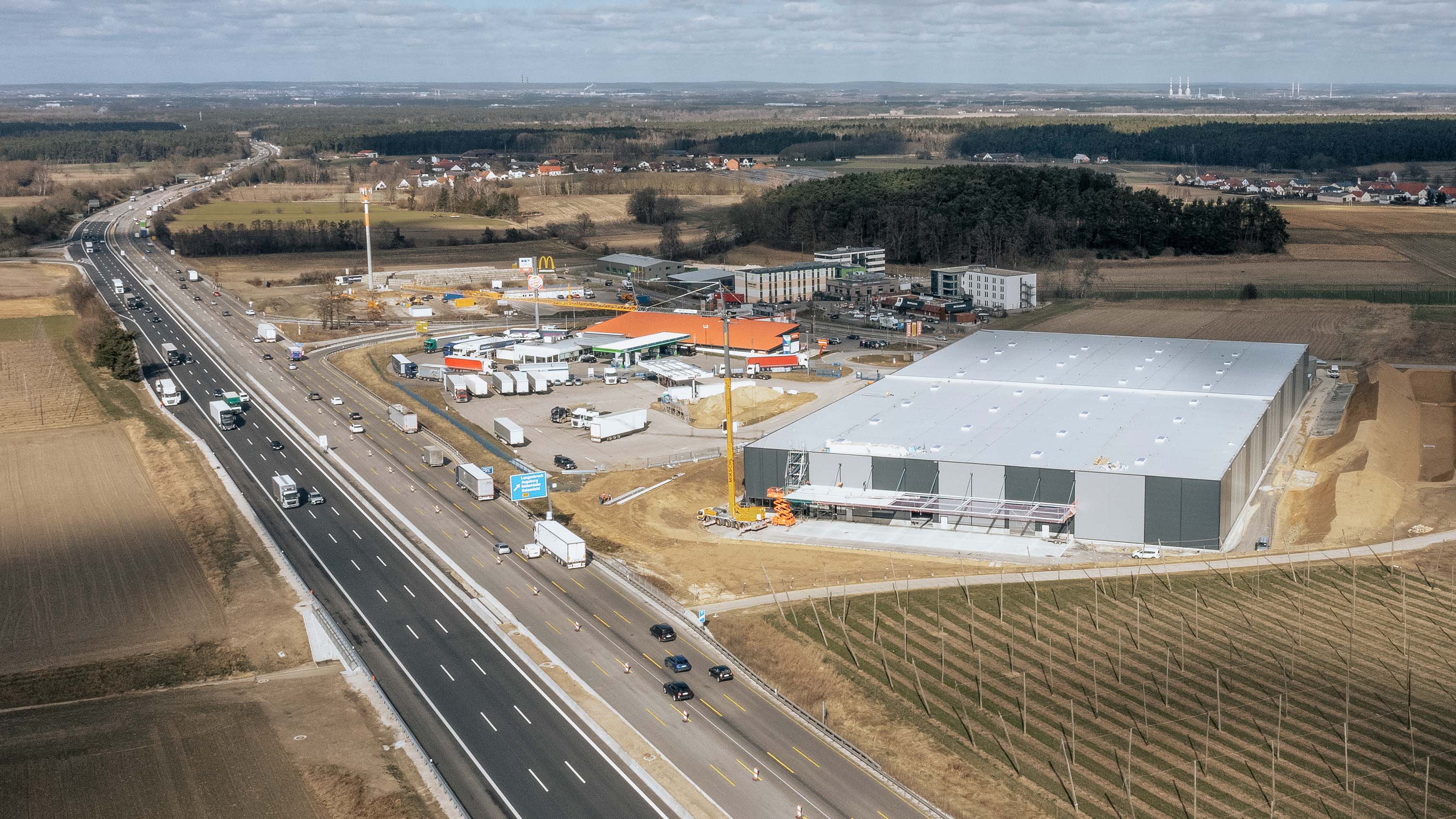 Luftaufnahme einer Logistikhalle in der Nähe einer Autobahn