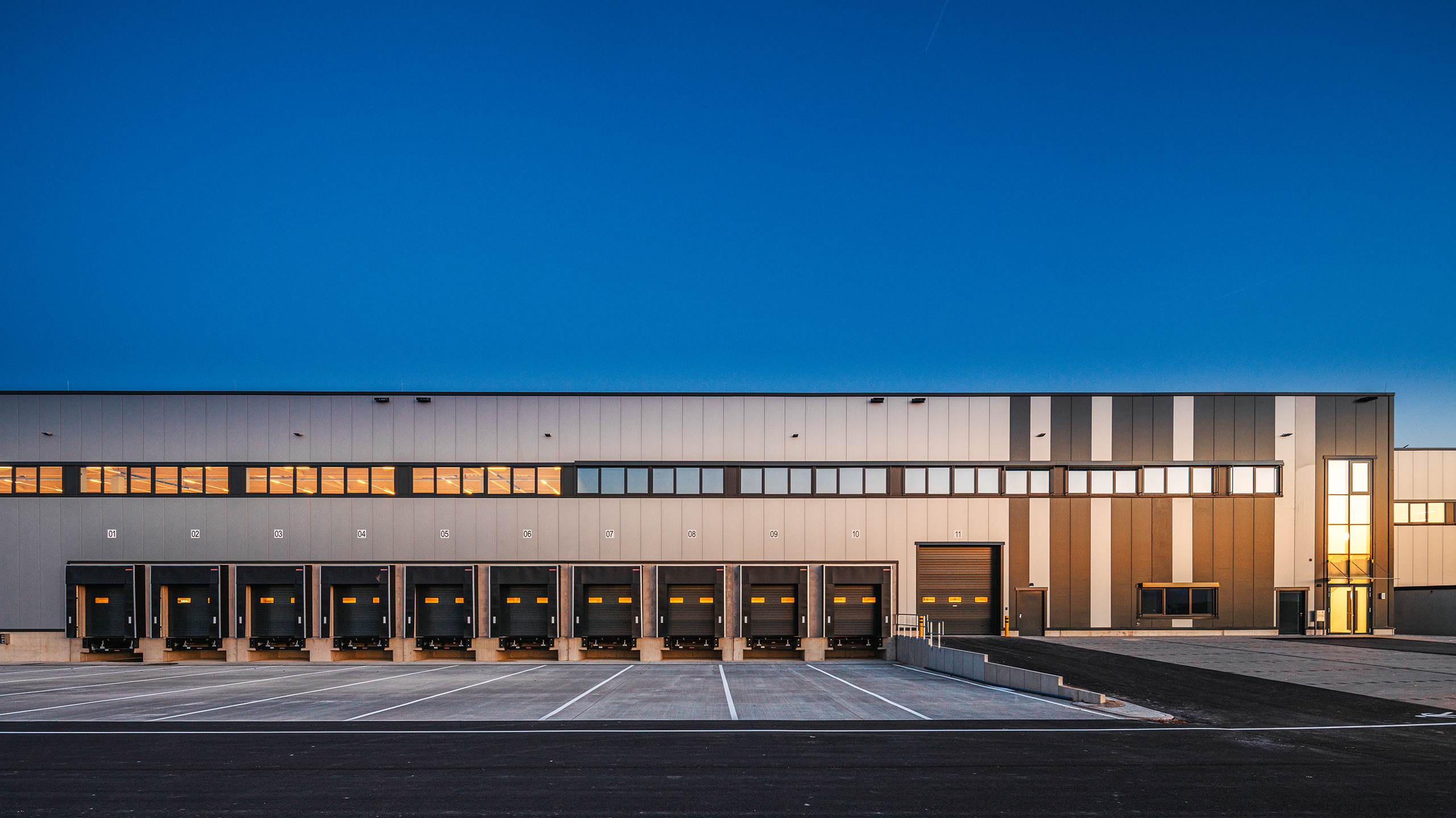 EQT Krostitz | fabrikon-Logistikhalle im Abendlicht: Tiefhof mit Überladebrücken | © fabrikon