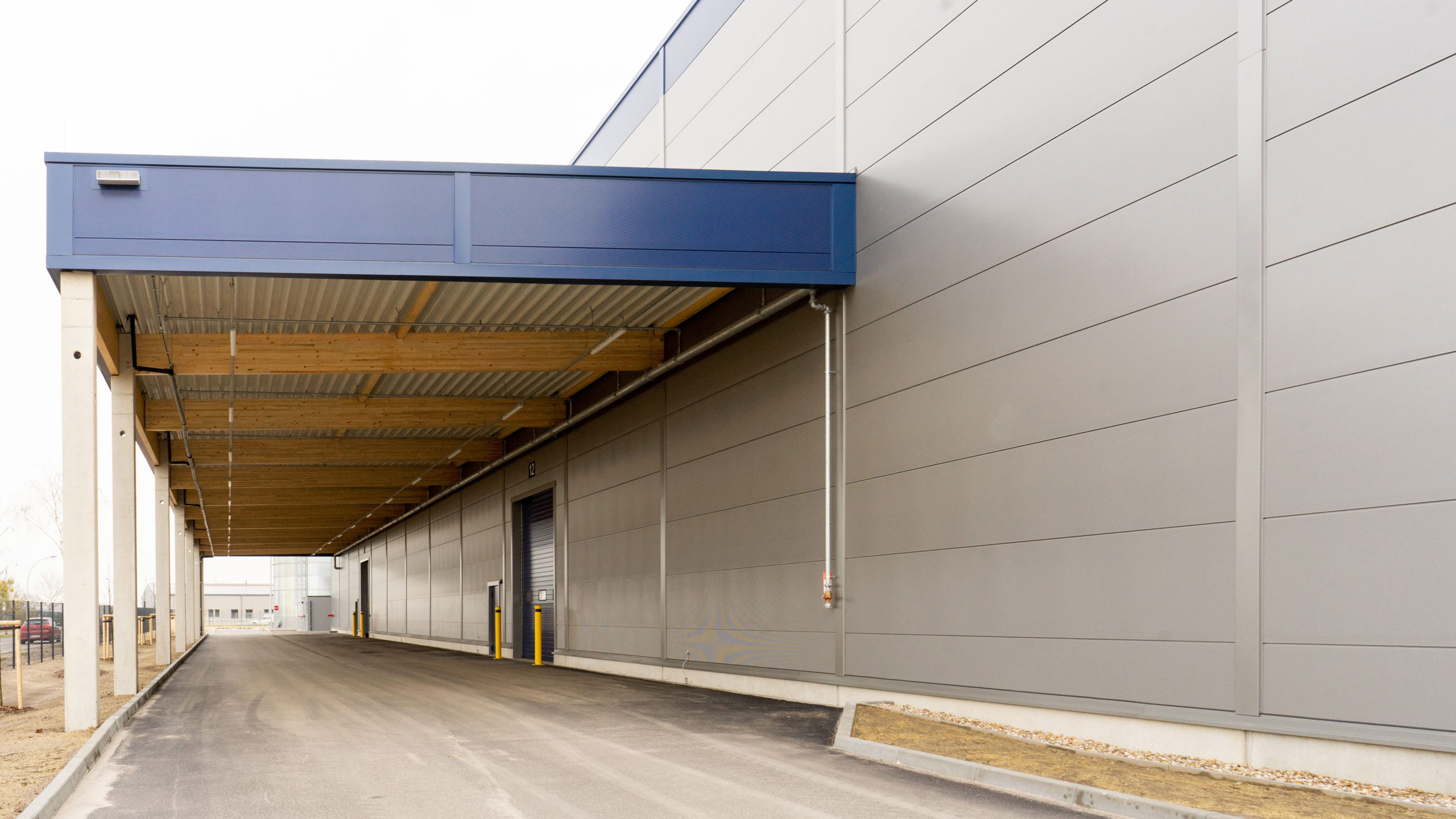 Logistikhalle fabrikon in Berlin Herzfelde, Blick auf das Vordach mit Holzkonstruktion für die seitliche Be- und Entladung.