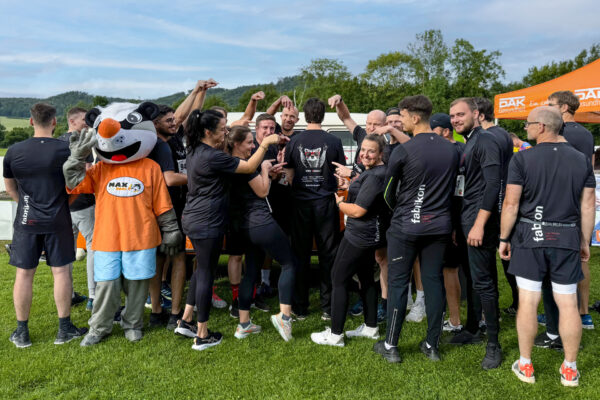 Gruppenfoto der fabrikon-Teilnehmer mit DAK-Firmenlauf Maskottchen