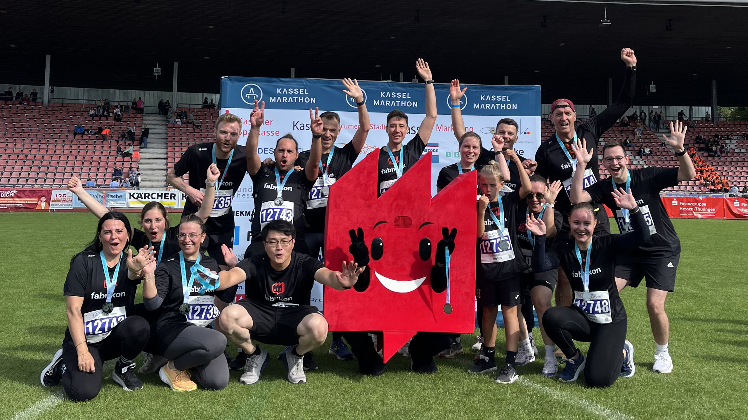Gruppenbild von Team fabrikon mit Maskottchen fabrikonchen auf dem Kassel Marathon 2025