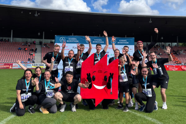 Gruppenbild von Team fabrikon mit Maskottchen fabrikonchen auf dem Kassel Marathon 2025